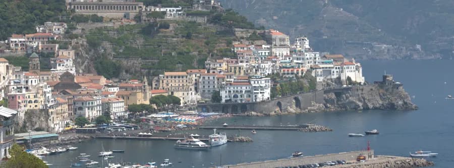 view of a marina and houses built upon the cliffside on the Amalfi Coast