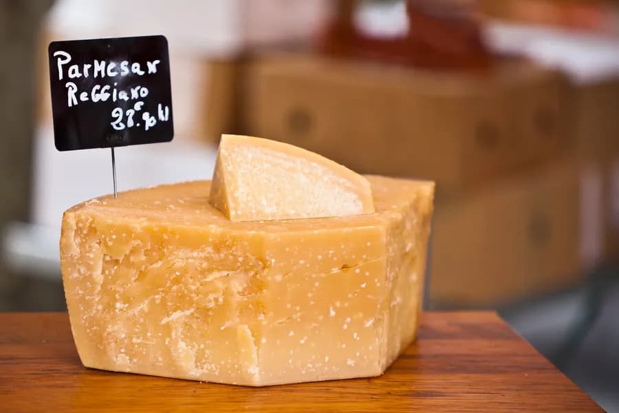 a small block of parmesano reggiano on display in a shop