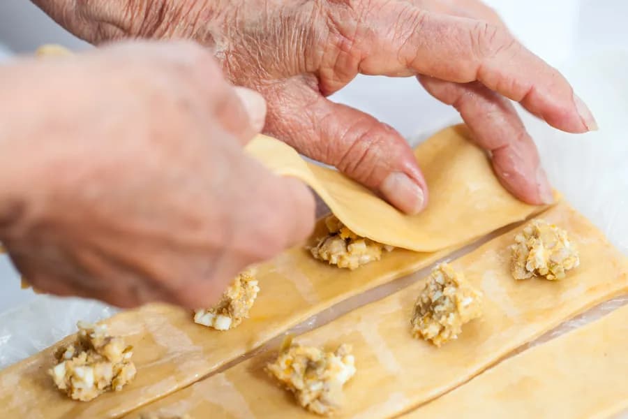 detail of a chef's hands preparing fresh ravioli