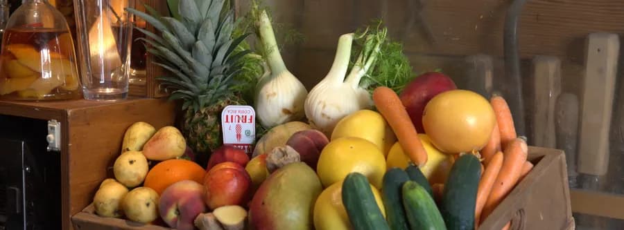 Crate of vegetables including carrots, cucumber, and peppers at a restaurant in Florence