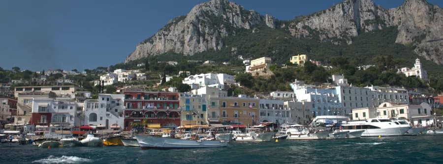 view from water of marina with shoreline and cliffs in Capri