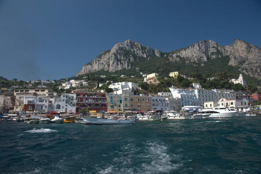 view from water of marina with shoreline and cliffs in Capri