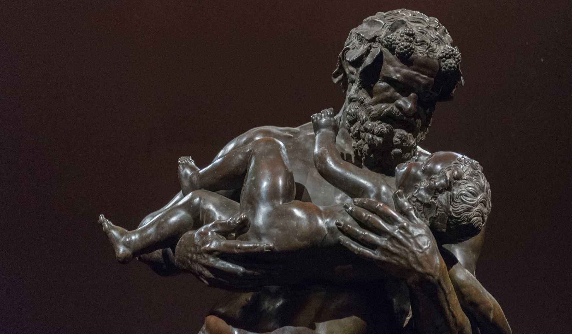 Statue of bearded man holding baby at the Uffizi Gallery in Florence