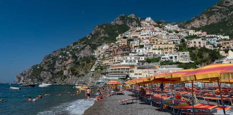 View of black sand beach with Positano rising in the background