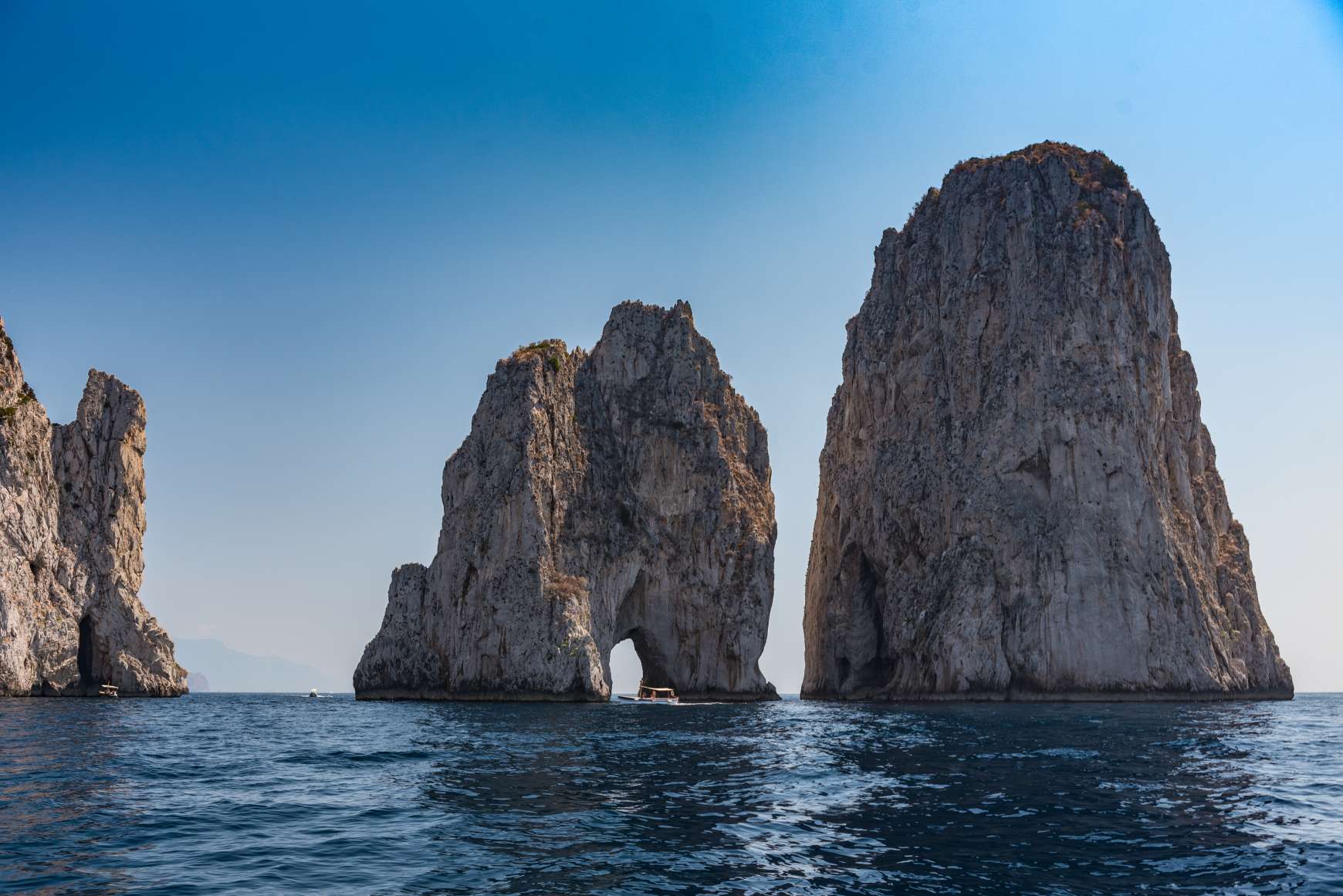 The three Faraglioni rocks of Capri jutting out from the sea