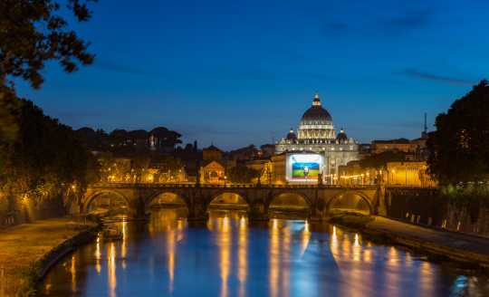 Illuminated evening view of St. Peter's Basilica in Rome